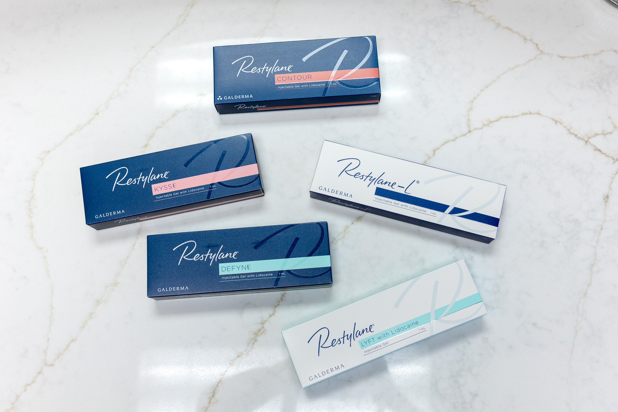 Close up of 5 boxes of Restylane dermal filler near Belle Meade on a white marbled table.