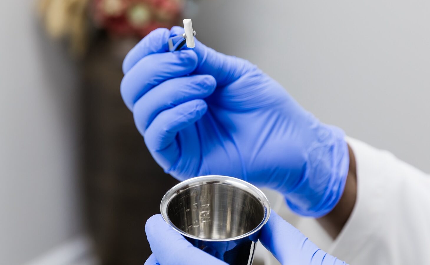 Close up of an Ona Skincare provider holding a tablet for hormone replacement therapy near Belle Meade over a metal container.