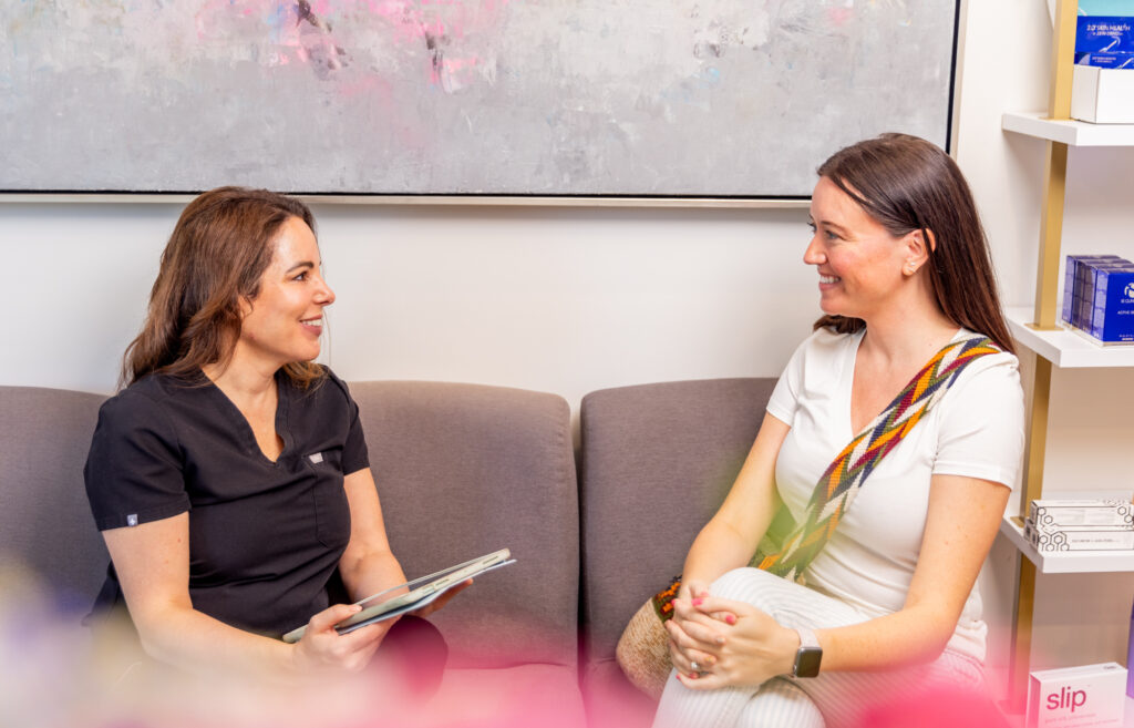 2 Ona Skincare providers discussing a patients' custom treatment plan for using our LED bed in East Nashville.