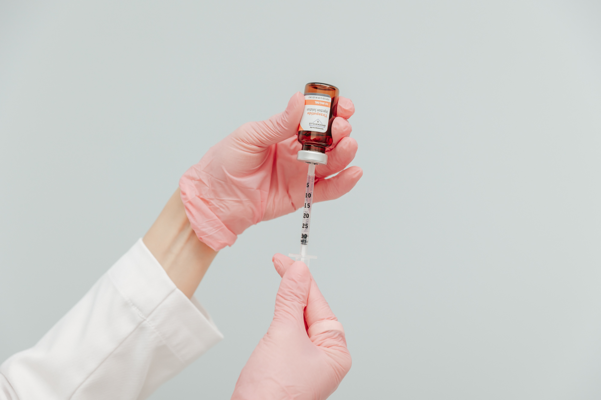Close up of gloved hands prepping a vial of semaglutide for weight loss injections in Nashville.
