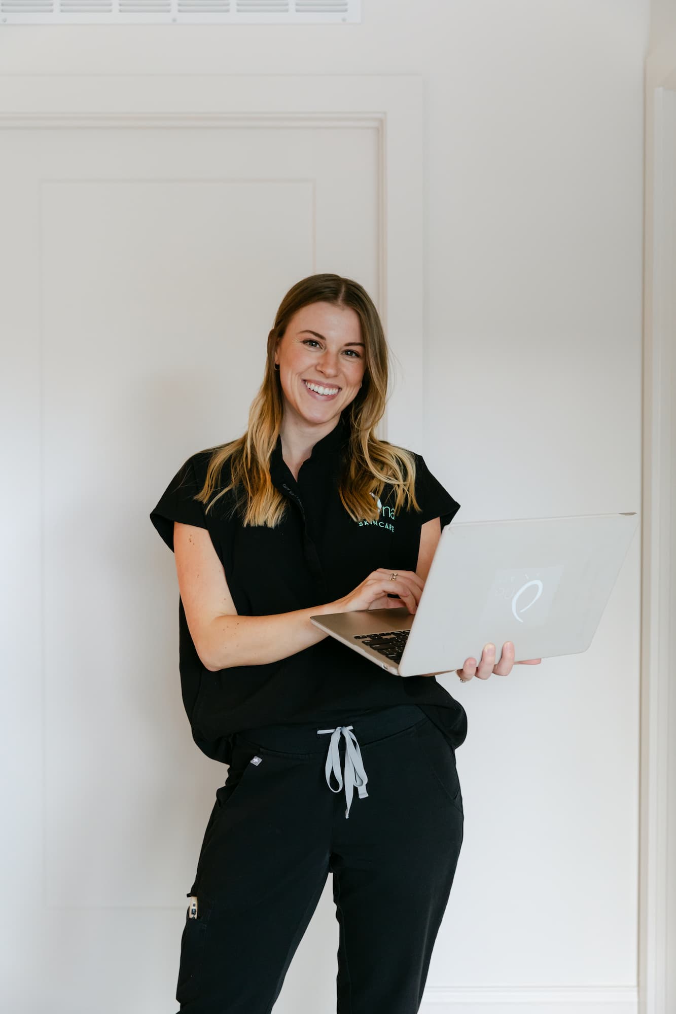 An Ona Skincare provider standing with a laptop, ready to explain peptides in Nashville.