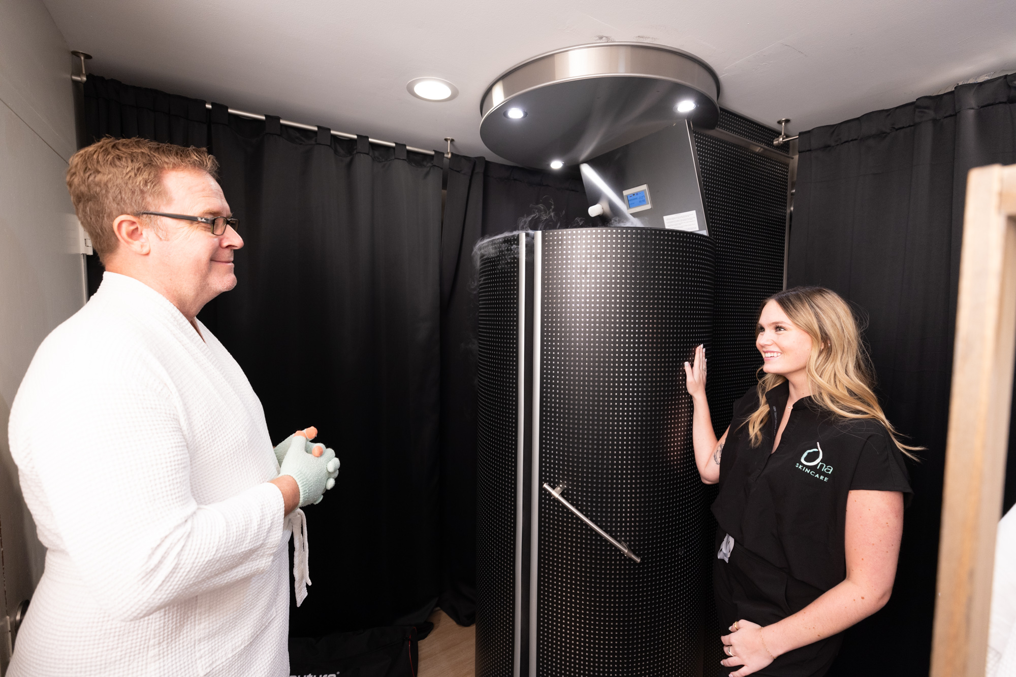 An Ona Skincare provider shows a client to the chamber for cryotherapy near Brentwood.