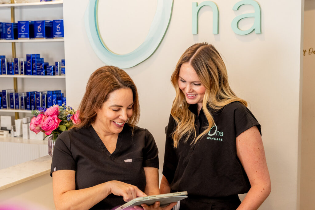 Two Ona Skincare providers meet to discuss a patient's treatment plan with Sculptra near Brentwood. 
